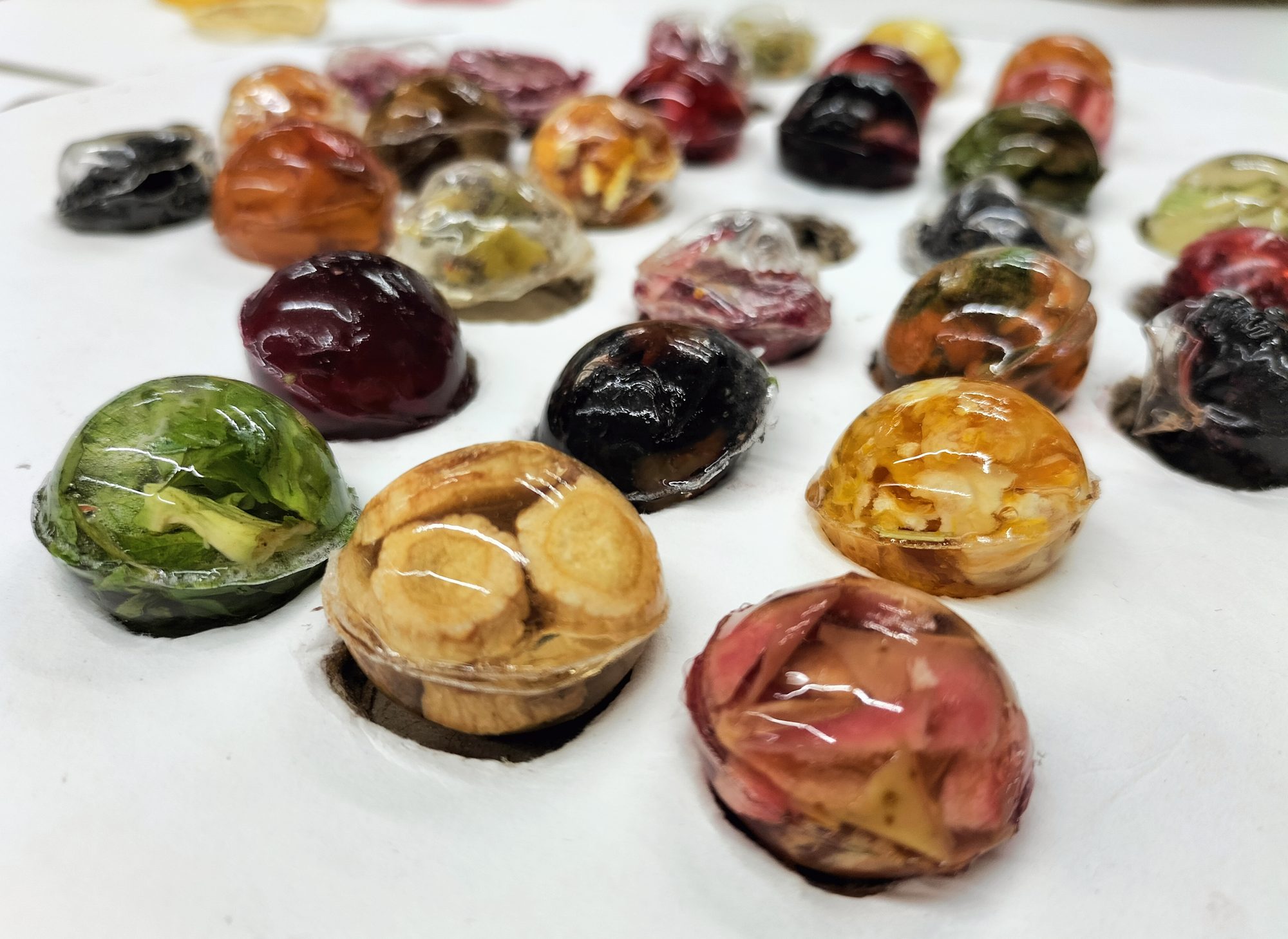 Nahaufnahme bunter Getränkeperlen aus Agartine mit Frucht- und Kräuterfüllung